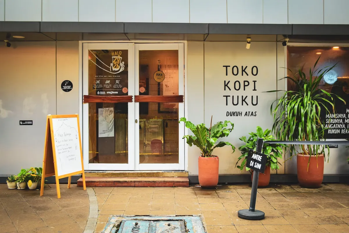 Welcoming coffee shop entrance with outdoor plants and a front entrance.